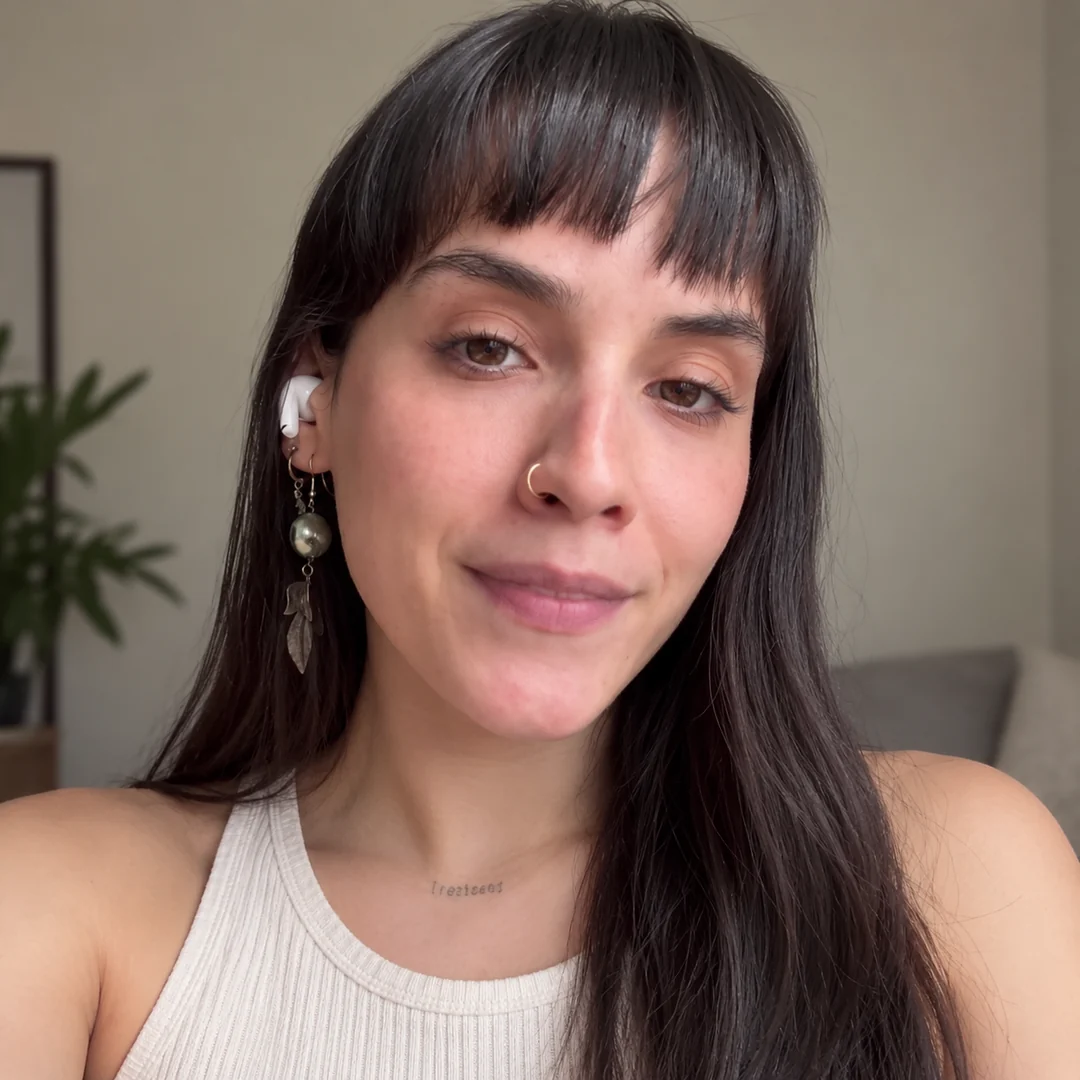 Mulher sorrindo, olhando para a câmera, em casa
